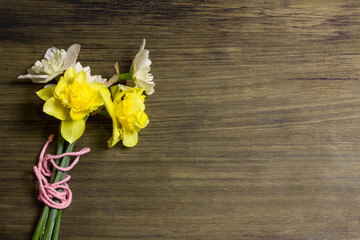 Fresh spring bouquet of daffodils. Yellow and white daffodils on a wooden background.