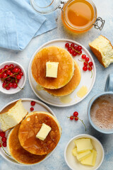 Fluffy Japanese Souffle pancakes with honey, butter and red currants  on a white plates. Asian dessert for breakfast. Top view