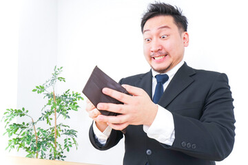財布を見て驚くビジネスマン