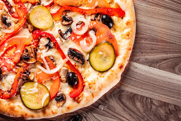 vegetarian pizza with Mozzarella cheese, grilled zucchini, mushrooms, red onion, pepper and olive. Italian pizza on wooden table background