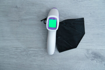 Black mask FFP2 for Covid-19 protection and thermometer