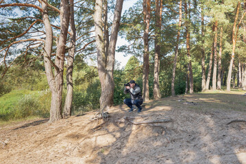 Obraz premium Man nature photographer taking pictures in the forest.