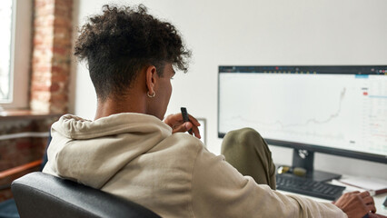 African american trader investor vaping electronic device while working on pc