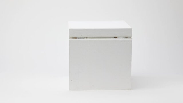 rotating abstract white painted wooden box on white background, stop motion