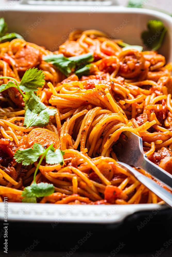 Wall mural baked spaghetti pasta with sausages in tomato sauce in oven dish.