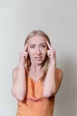 beautiful blonde woman has a headache dressed in an open dress on a white background