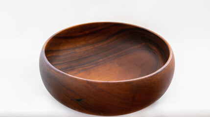 A round carved cedar tree wooden bowl on the white background.