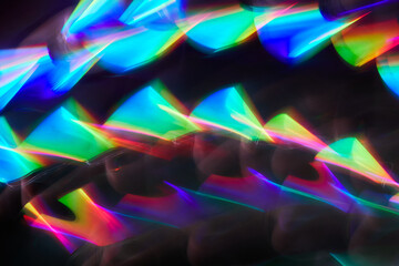 Blurred bright rainbow light. Lens or prism dynamic flare. Draving shiny spots. Dark background....