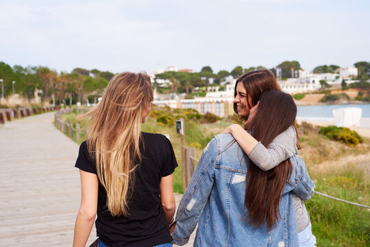 Young Friends Strolling On Boardwalk