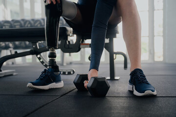 Close up of disabled man with prosthetic leg doing bicep curls
