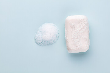 Obraz na płótnie Canvas Soap bar and foam on white background, top view. Mockup for design