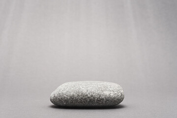 grey stone, pebble podium on gray background for product presentation with rays