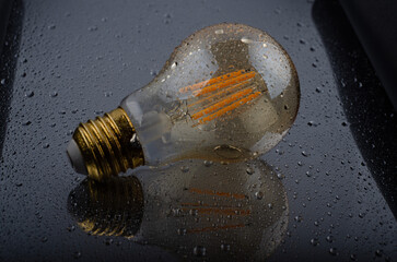 reflective modern wet Edison LED lamp splattered with moisture