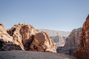 Fototapeta premium The ancient city of Petra in Jordan. Red sandstone mountains on a clear day. Caves in the rock. Landscape. Colorful photos.