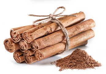 Cinnamon dried bark strips and cinnamon powder, sweet-smelling brown substance used in cooking, isolated on white background.