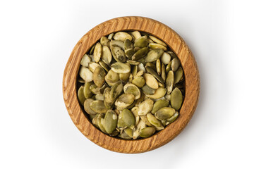 Pumpkin seeds on wooden bowl isolated on white background.