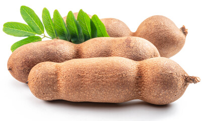 Ripe tamarind fruit pods and leaves isolated on white background.