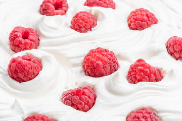 Fresh raspberries in the yoghurt or cream. Top view.