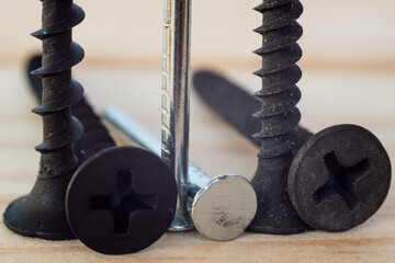 Construction abstraction. Industrial education. Hardware, screws, nails, for metal, for wood, for drywall. Bits, P2, P1, PZ2, PZ1. The screw is screwed into a wooden block. Screw confirmation.