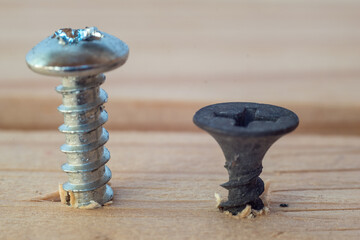 Construction abstraction. Industrial education. Hardware, screws, nails, for metal, for wood, for drywall. Bits, P2, P1, PZ2, PZ1. The screw is screwed into a wooden block. Screw confirmation.