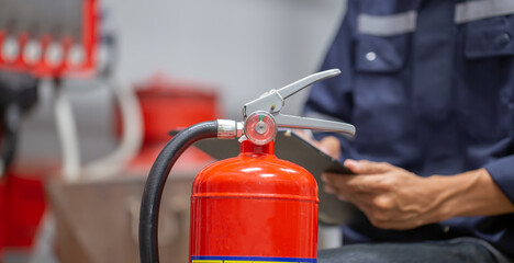 Engineer are checking and inspection a fire extinguishers tank in the fire control room for safety training and fire prevention.