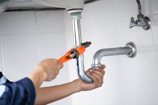 plumber at work in a bathroom, plumbing repair service, assemble and install concept.