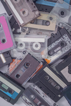 Set of old retro audio cassettes on white background. Best of 90's hits. Flat lay, creative concept.