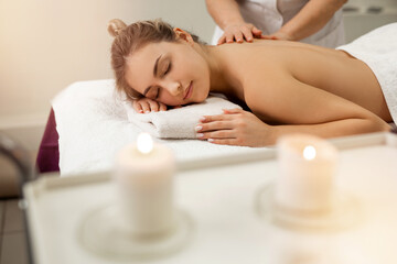 Obraz na płótnie Canvas beautiful young woman on massage in salon 