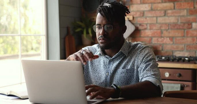 Irritated nervous Black man hipster remote employee read error message on laptop screen puzzled with unexpected problem bad online service work. Stressed young guy student get email about fail on exam