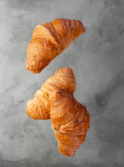 Flight of French croissants on a gray background.