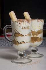 Dessert with Savoiardi cookies and cream. Tiramisu cookies. Close-up.