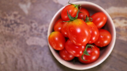 Fresh red tomatoes in a cup. Delicious fresh tomatoes from organic farm healthy vegetables on stone background. Selective focus