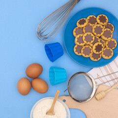 Blue background with ingredients for baking cookies. Flat lay creative concept. Cooking dessert