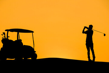 Golfers' hit golf ball toward the hole at sunset silhouetted
