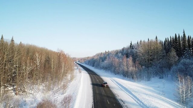 Countryside road through winter forest covered with hoarfrost.