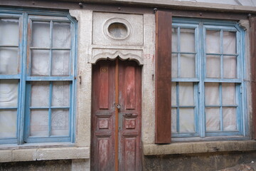 Vintage style door and window, Ottoman sultan's signature on top of wooden door and between two blue windows.