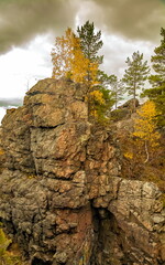 Autumn landscape with rocks, trees and sky with clouds