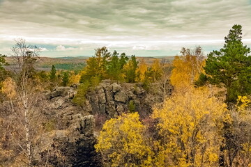 Autumn landscape with rocks, trees and sky with clouds
