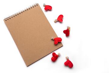Top view of open spiral blank notebook on white desk background with wooden clothespin. Isolated on white backdrop.