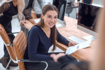 smiling business woman talks while sitting at an office Desk