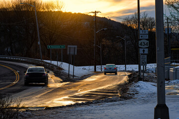The setting sun turns the water from the melting snow into a golden highway.  An intersection in...