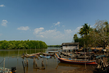 Many Thai wooden head long tails and small Thai traditional fishing boats anchored in the canal with mangrove at Ao Luek District, Krabi, Thailand.