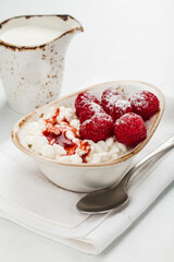 Close up of cottage cheese and berries bowl on a white table