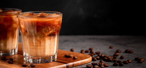 Ice coffee in a glass with cream poured over.