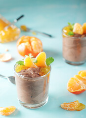 Chocolate mousse dessert with tangerines in glasses	