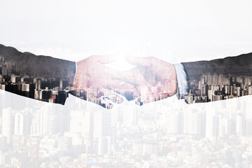 Double exposure of two businessmen hand shaking with city scape concept.
