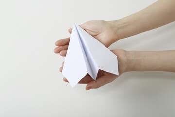 Close up of woman holding paper airplane