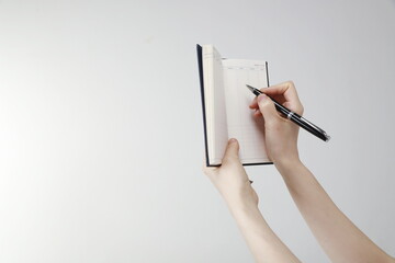 Close up of woman writing on notepad