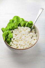 Close up of cottage cheese and spinach bowl on a white table