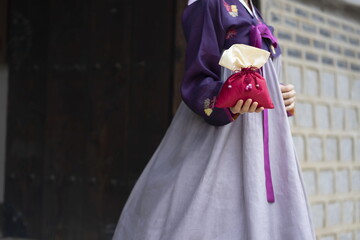 Woman in Korean traditional clothes holding lucky bag